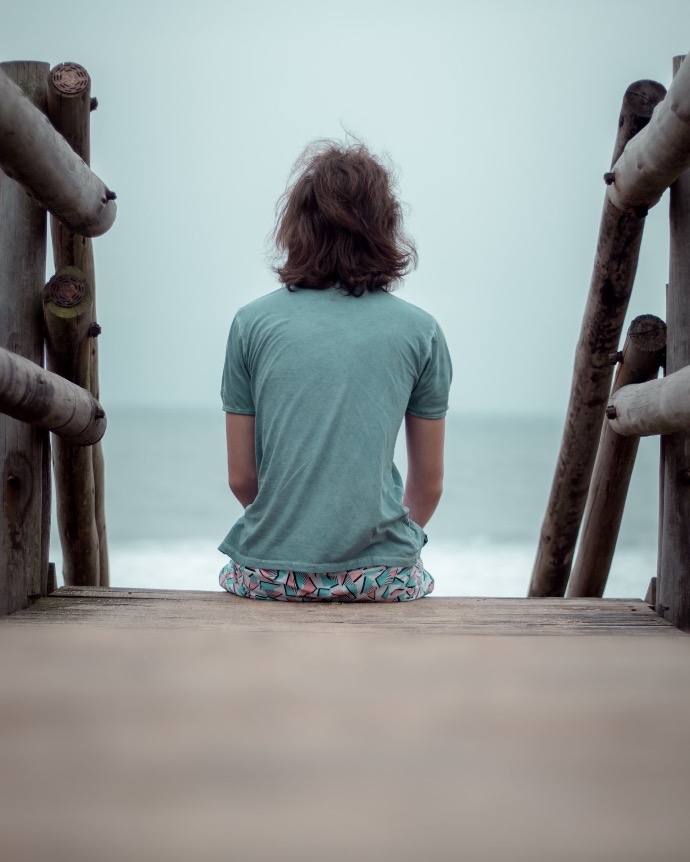 girl in green t-shirt standing on beach during daytime